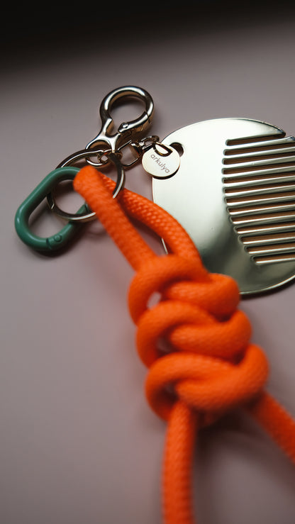 Keychain with carabiner and a decorative comb orange