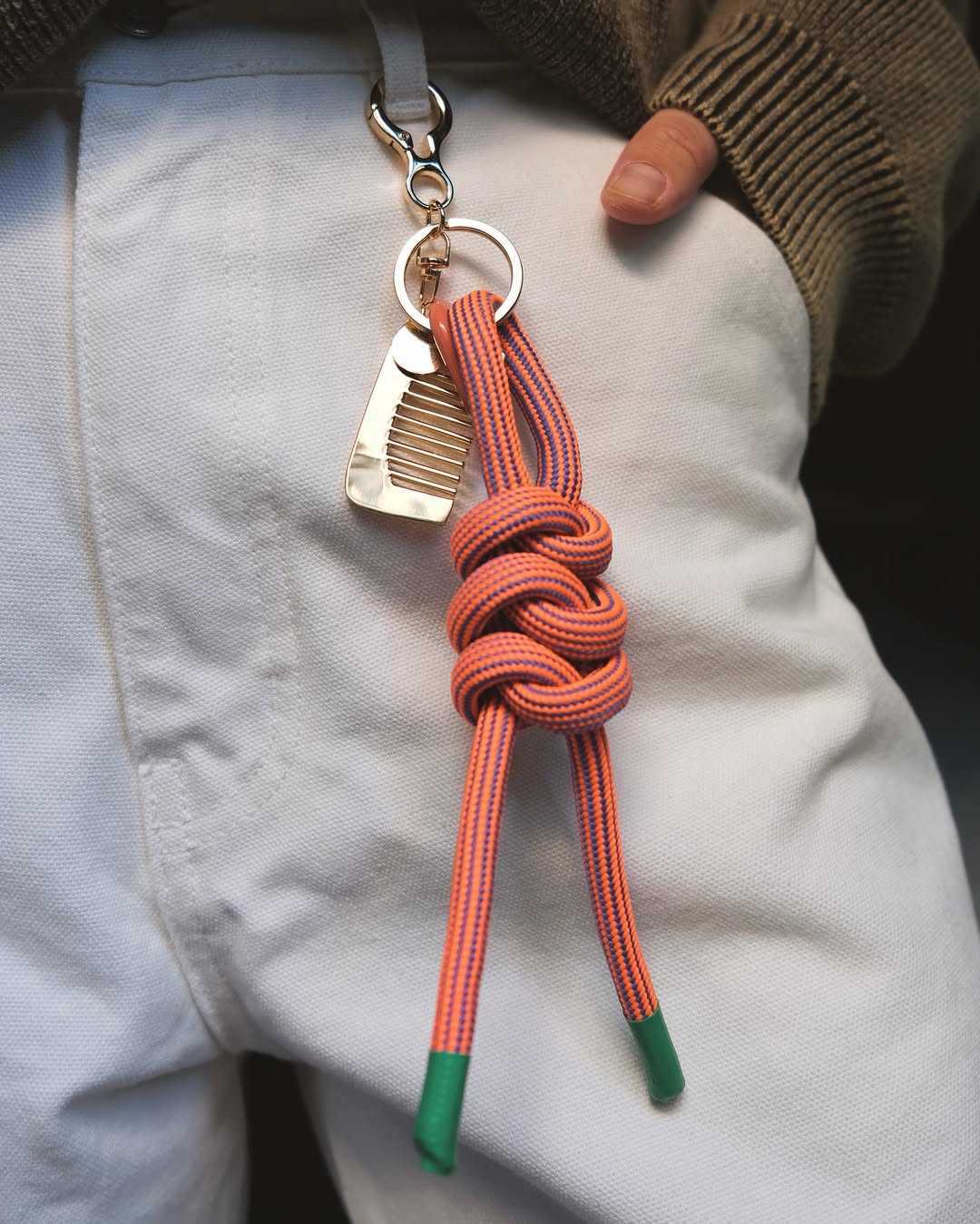 Keychain with carabiner and a decorative comb peach/green on jeans